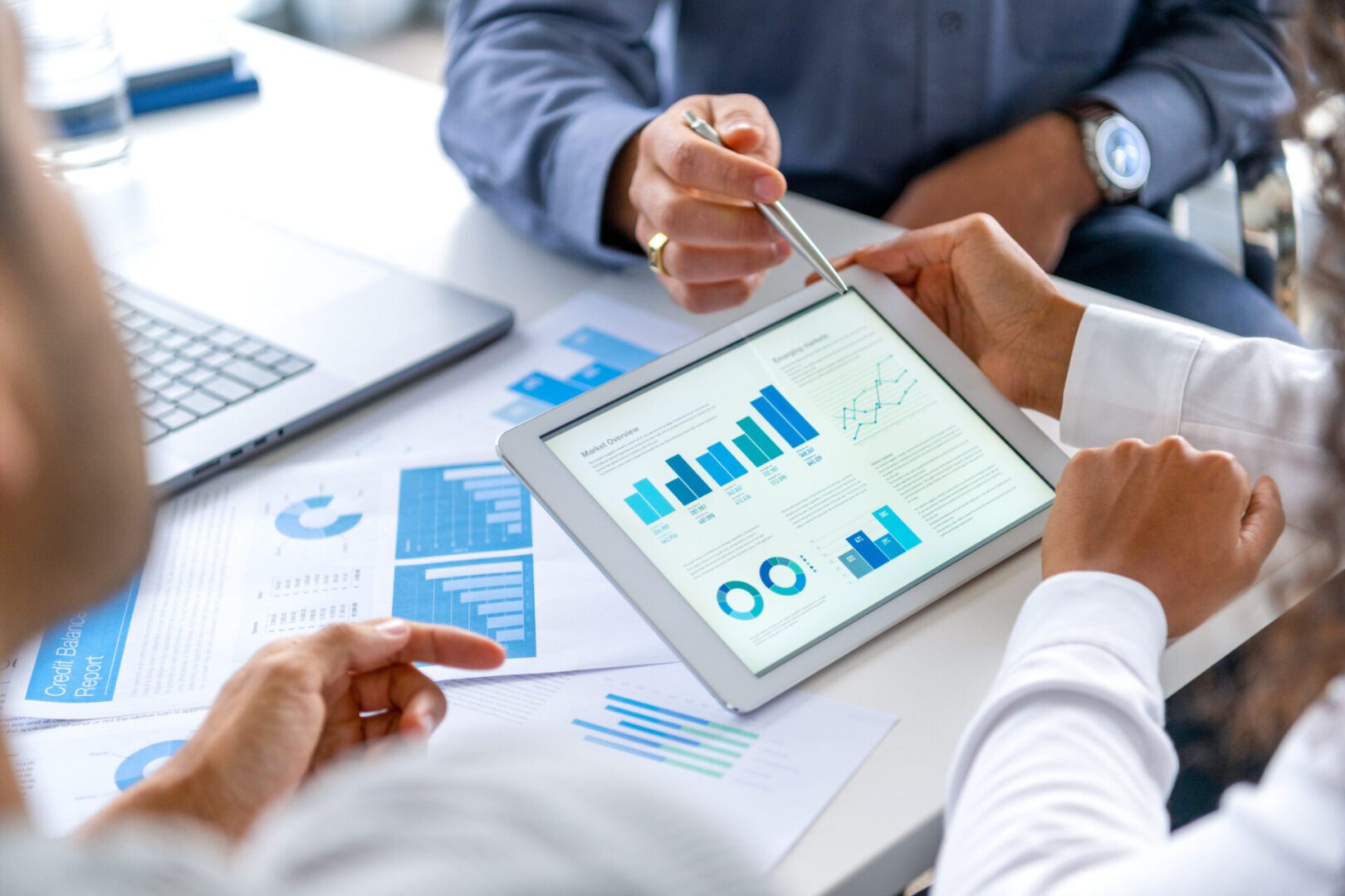 People reviewing business data on tablet.